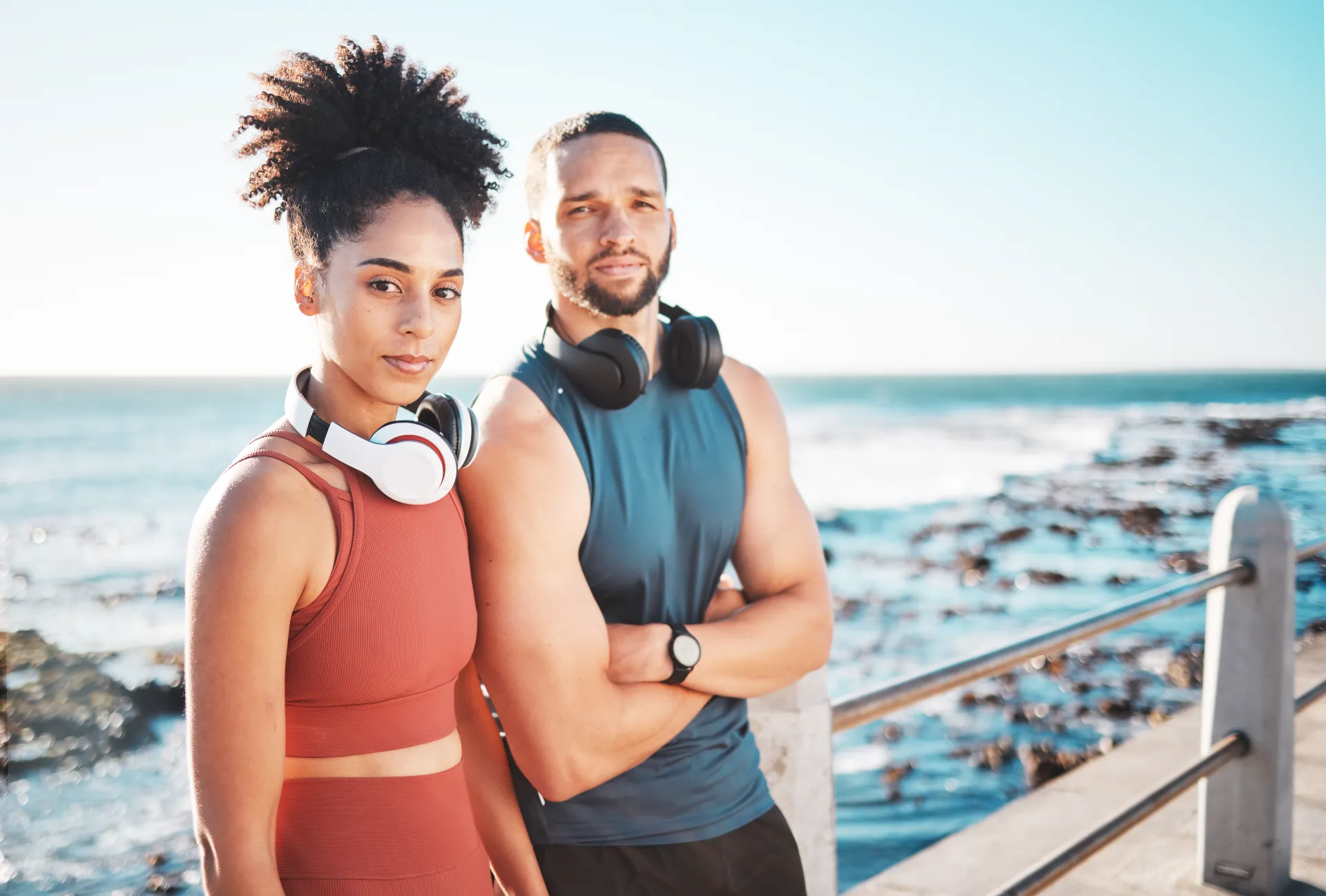 athletic couple posing near the ocean utc