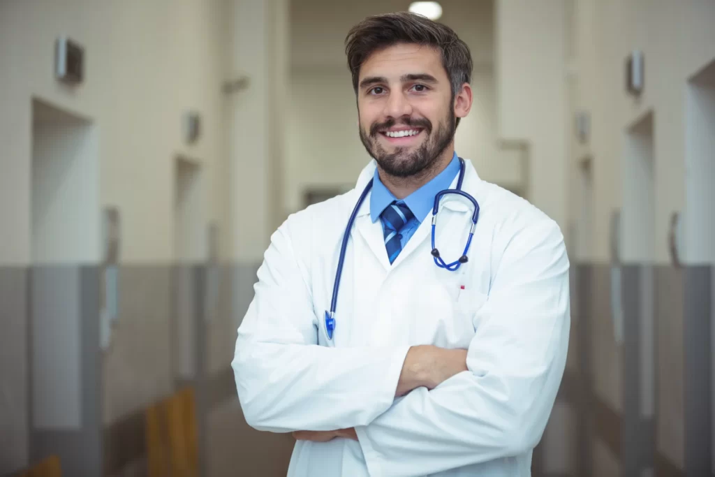 smiling man doctor wearing white coat in hospital utc